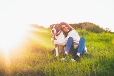 Çekici, gülümseyen bir kadın güzel köpeğine sarılıyor. American Stranfrod