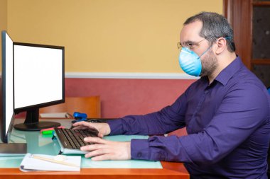 Tıbbi maskeli bir adam evde çalışıyor. Telesekreter kavramı
