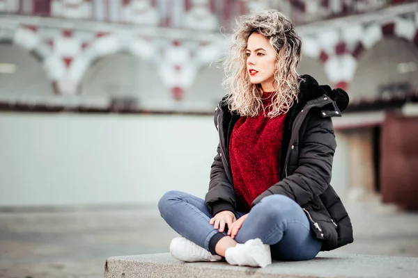 Lockigt Blond Kvinna Som Sitter Näbben Fritidskläder — Stockfoto