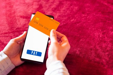 Çevrimiçi alışveriş uygulaması ve kredi kartıyla insan eli akıllı telefon.