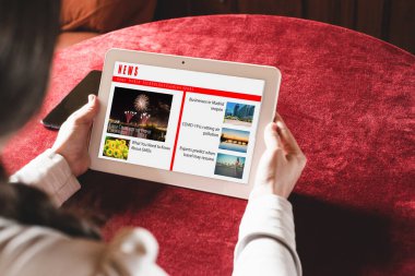 Tabletten haberleri okuyan kadın.