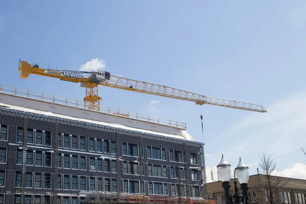 Portland, Oregon / USA - Circa 2019: A yellow construction crane on top of a building. — Stock Image Portland, Oregon / USA - Circa 2019: A yellow construction crane on top of a building. Stock Image