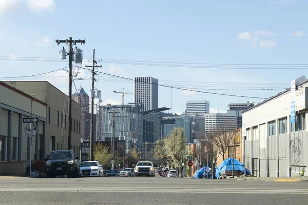 俄勒冈州波特兰- 2019年：在街道旁边的人行道上看到的无家可归的帐篷和在远处看到的俄勒冈州波特兰市的天际线. 免版税图库照片