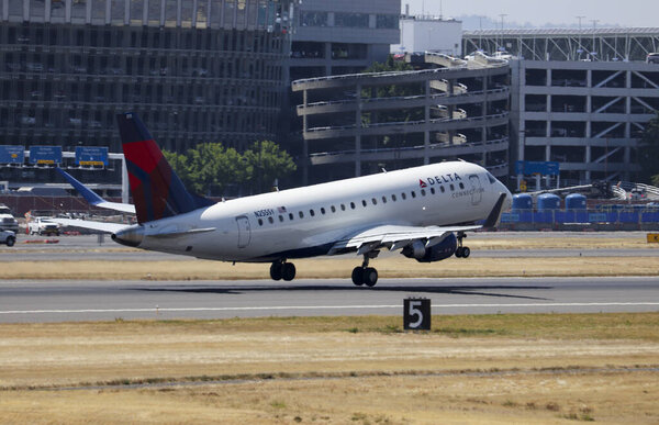 Portland, OR / USA - circa 2018: Delta Connection Embraer 175 taking liffting off the runway at Portland International Airport.