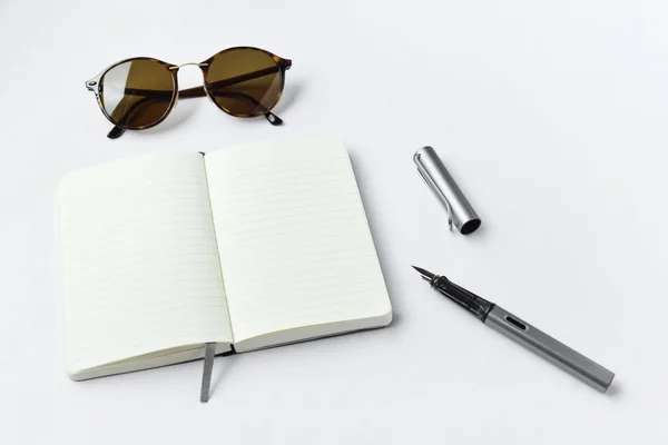 Sunglasses, notebook, and pen, on white background — Stock Photo, Image