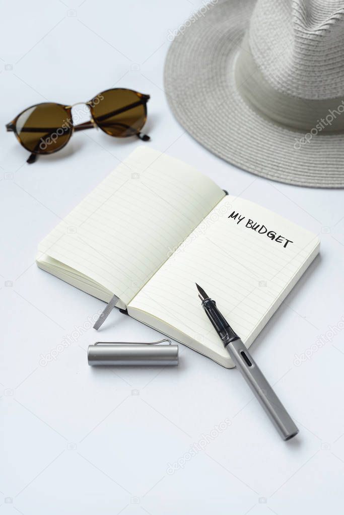 Sunglasses, notebook, pen, and hat, on white background