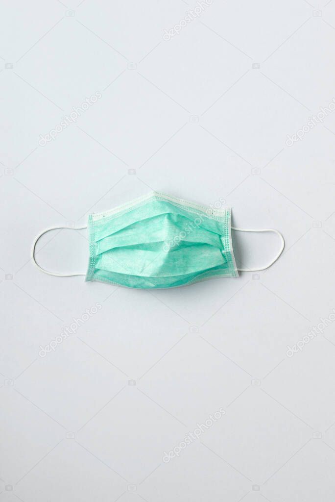 Still life of am unused green face mask on white background