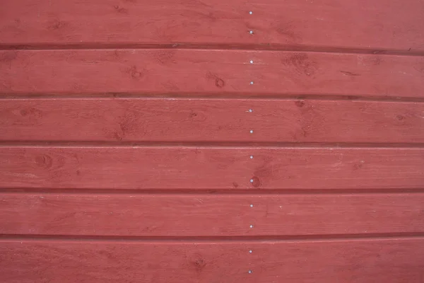 Pannelli orizzontali in legno con fessure e nodi sono verniciati di rosso . — Foto Stock