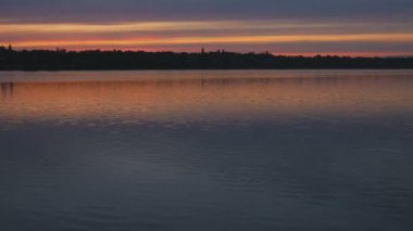 Sakin bir nehrin arkasında yaz günbatımı