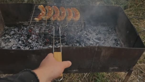 Grade de grelha e churrasqueira e malha de mangala. Preparação de linguiça em um fogo — Vídeo de Stock