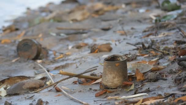 Špinavý a ucpaný břeh nádrže s rezavými plechovkami a rozbitými lahvemi — Stock video