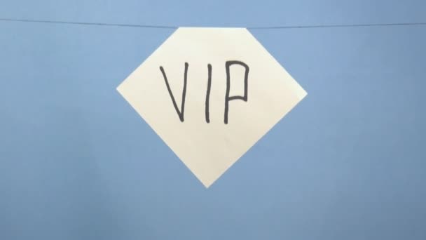 Brennendes und rauchendes weißes Blatt Papier mit schwarzer Aufschrift "vip" auf blauem Hintergrund — Stockvideo