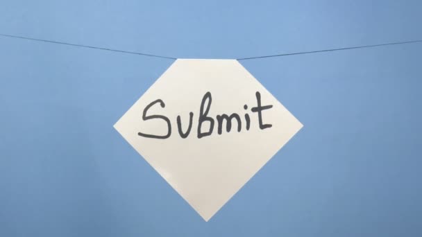 Hoja de papel blanco ardiente y humeante con una inscripción negra "submit" sobre un fondo azul — Vídeos de Stock