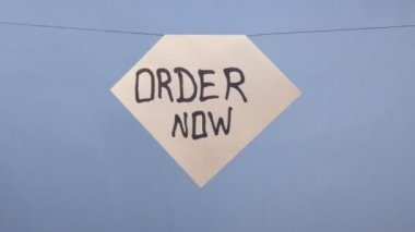 A man hangs a white sheet of paper with a black inscription 