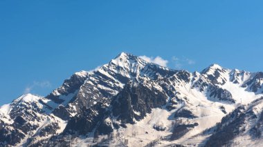 Krasnodar bölgesi, Krasnaya Polyana tatil köyü, Kafkasya sıradağları, Soçi 'de mavi gökyüzüne karşı güzel karla kaplı dağlar.