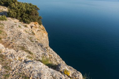 Uçurumun tepesinden deniz manzarası. Dağ ve mavi deniz arkaplanlı güzel bir manzara. İnsansız deniz manzarası manzarası. Bir turizm beldesi.