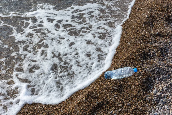 Plastic bottle on the beach. Plastic pollution of nature. Environmental protection. Garbage on the beach. A bottle of water.