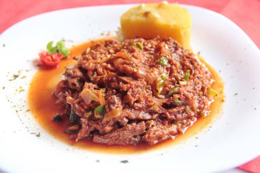 Ropa vieja, dilimlenmiş et, sebze, domates, biber ve soğan ile yapılan çok popüler bir geleneksel Küba ulusal yemeği, Küba 'nın Camaguey kentinde lüks bir restoranda servis ediliyor..