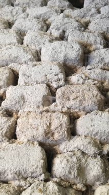 Tuğla duvar. Çamur, kuru saman ve küçük taşlardan oluşan eski bir yapı. Kahverengi doku. Antika, kırsal, kırsal.