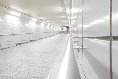 New York Manhattan metrosuna giden parlak beyaz fayanslı tünel geçidi.