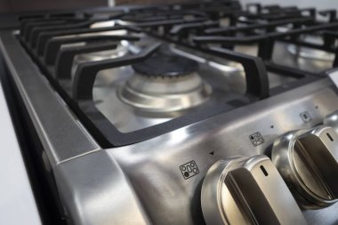 close up of modern stainless steel cooking range burners and but