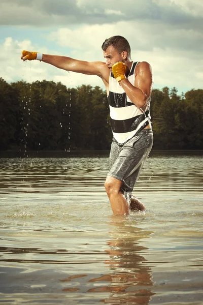 Чемпион по кикбоксу тренируется в воде — стоковое фото