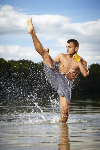 Mistrz kick-boxer szkolenia zabójcze kopnięcie w wodzie — Zdjęcie stockowe