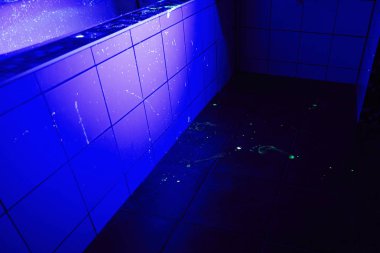 Clean place of bloody crime under ultra violet black light clipart