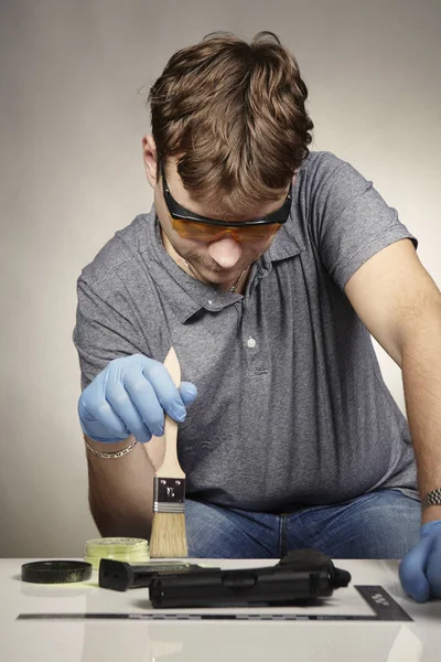 Developing of fingerprints on seized handgun by criminologist — Stock Photo, Image