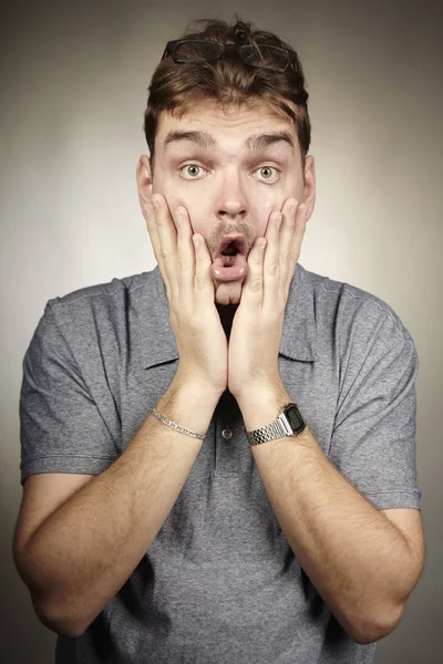 Homem adulto surpreso faz rostos em estúdio — Fotografia de Stock