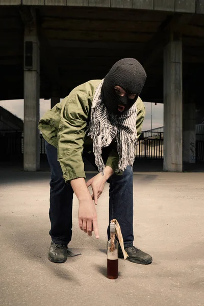 Анархист в балаклаве берёт бутылочную бомбу Молотова — стоковое фото