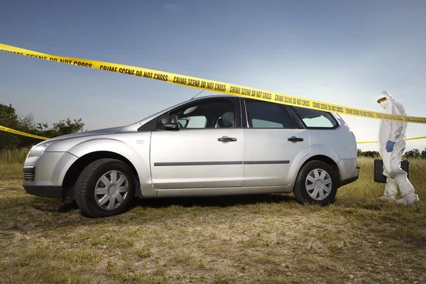 Criminologist technician collecting evidences and traces from around car — Stock Photo, Image