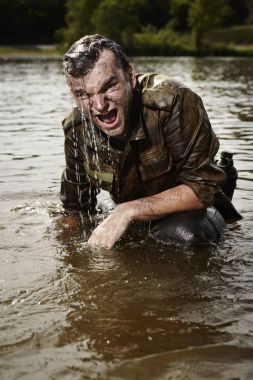 Islak ve kirli nehir akışı kızgın üniformalı asker