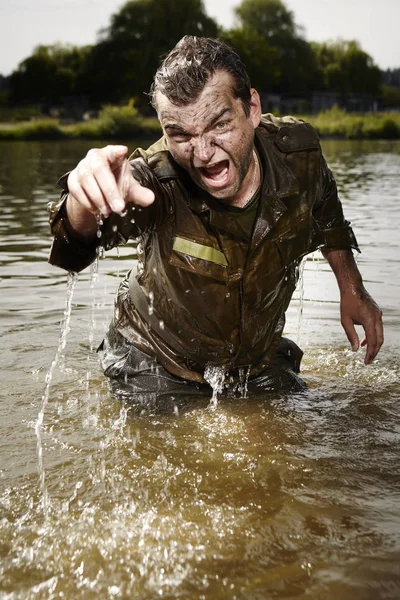 Wet and dirty soldier in uniform angry in river stream — Stock Photo, Image