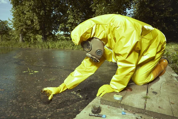 Tudós kémiai védő ruha gyűjt mintát rosszul szennyezett víz — Stock Fotó