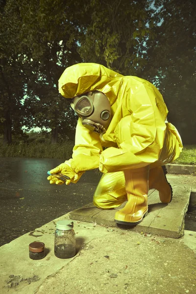 Científico en traje de protección química recogiendo muestras de agua altamente contaminada — Foto de Stock