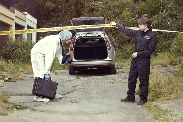 Policejní důstojník a technik, který pracuje na místě vyšetřování — Stock fotografie