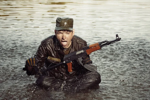 Crazy soldier in uniform after swimming in lake with assault rifle — Stock Photo, Image