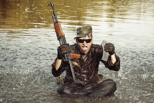 Crazy soldier in uniform after swimming in lake with assault rifle — Stock Photo, Image