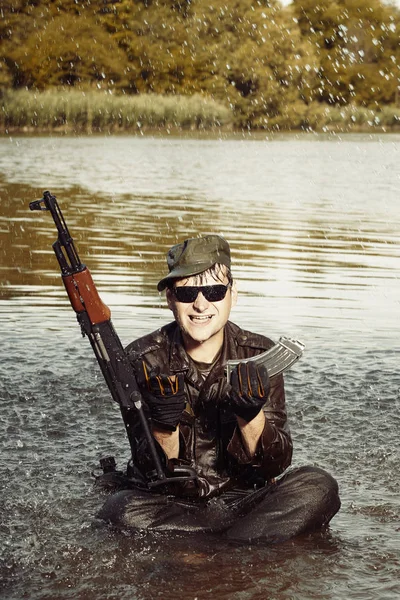 Crazy soldier in uniform after swimming in lake with assault rifle — Stock Photo, Image