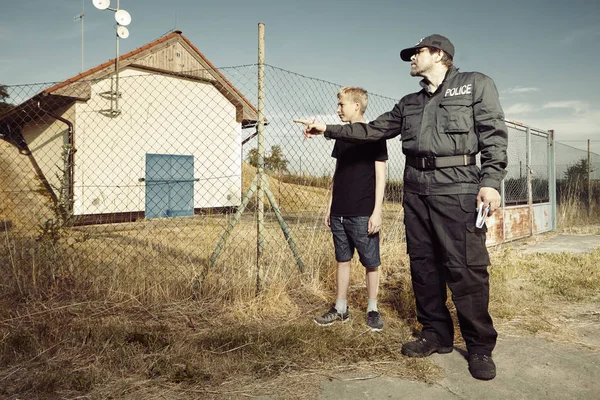 Tonårspojke svara att polisen mannen i fält — Stockfoto