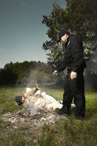 Jeune homme vagabond pris dans le parc par un policier — Photo