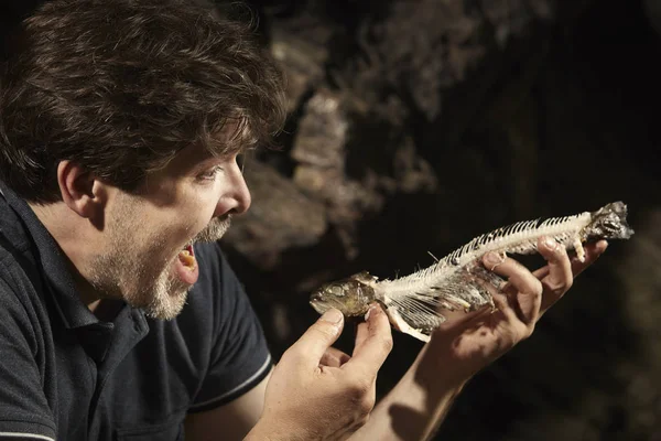 Man relaxing and eating hunted trout in wilderness — Stock Photo, Image