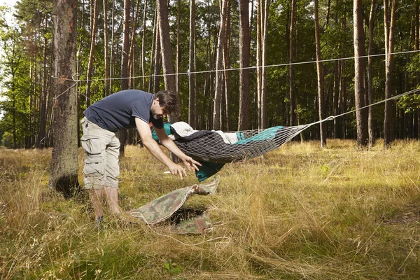 仲間と寝袋ハンモック ベッドを作る野生の森の男 — ストック写真