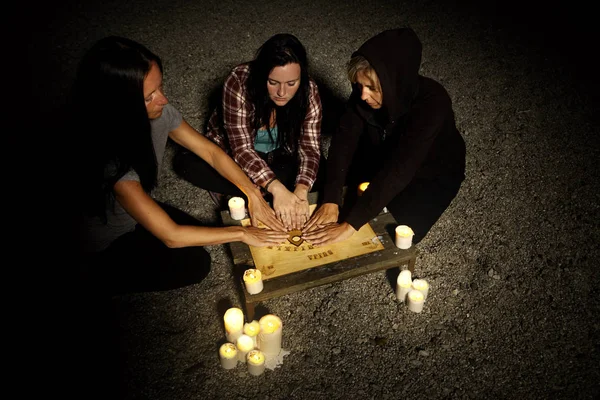 Três mulheres se comunicando com fantasmas na praia de verão — Fotografia de Stock