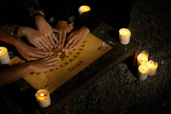 Mãos de bruxas no tabuleiro espiritual ouija — Fotografia de Stock