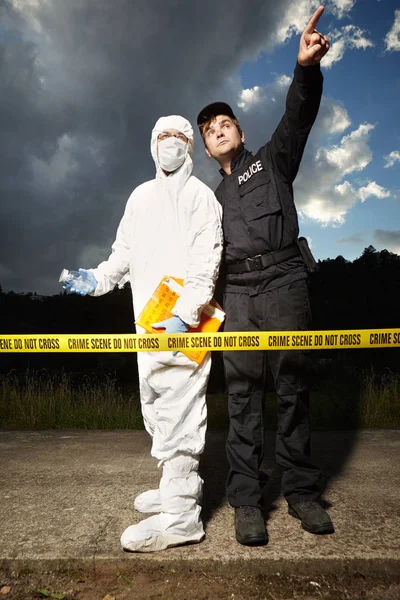 Técnico criminologista no local do crime atrás de fita adesiva com policial — Fotografia de Stock