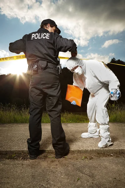 Politie man op de plaats van de misdaad met politie technicus — Stockfoto