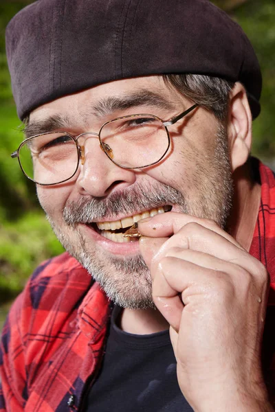 Modern prospector in hipster style biting to a golden nugget — Stock Photo, Image