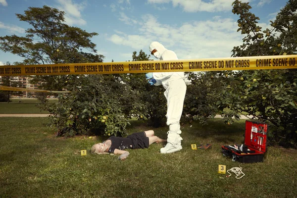 Technician working on collecting of evidences on victim's body — Stock Photo, Image